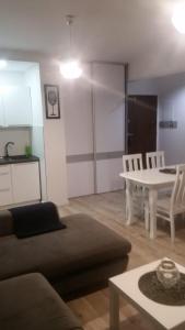 a living room with a couch and a table at Apartament Morski przy plazy in Darłówko +5 photos