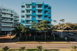 - un bâtiment bleu avec un restaurant en face dans l'établissement Apart Hotel Punta Sol, à Punta del Este