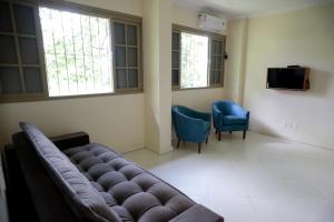 una sala de espera con sofá y 2 sillas en Residencial Mb en Conservatória