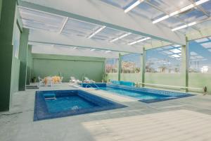a large swimming pool with a table and chairs at Apart Hotel Punta Sol in Punta del Este