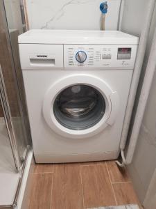 a white washing machine sitting in a room at Apartament L14, Mieszkanie dla Wszystkich in Konin