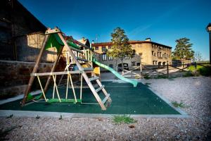 a playground with a slide in a yard at Apartamentos Turísticos Mallos de Huesca in Ayerbe
