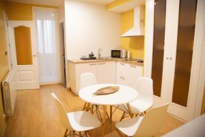 a kitchen with a white table and white chairs at SAN MARCOS in Almansa