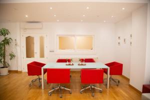a dining room with a white table and red chairs at SAN MARCOS in Almansa +15 photos