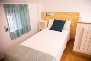 1 dormitorio con cama blanca grande y almohada azul en SAN MARCOS, en Almansa