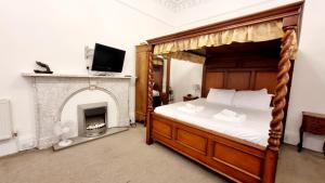 1 dormitorio con cama con dosel y chimenea en The Guards Hotel en Edimburgo