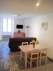 ein Wohnzimmer mit einem Tisch und einem Sofa in der Unterkunft Résidence Maurice in Ax-les-Thermes