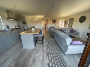 a kitchen and living room with a couch and a table at 31 Cherry East Riding of Yorkshire Hot Tub & Fishing in Garton