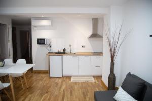 a kitchen with white cabinets and a table and a vase at ELIZABETH TOWERS in Almansa