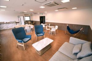 舞鶴的住宿－Manabiamu 4F - Vacation STAY 58913v，一间设有椅子、一张沙发和一张桌子的等候室