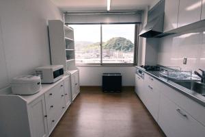 舞鶴市にあるManabiamu 4F - Vacation STAY 58913vの白いキャビネットと大きな窓付きのキッチン