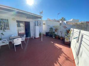 a balcony of a house with a table and chairs at Centrico Atico Apt Sleeps 4 with Patio in Almuñécar