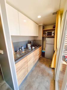 a small kitchen with a sink and a refrigerator at Bungalow Home Sweet Home - Logement complet in Biograd na Moru