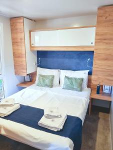 una camera da letto con un grande letto con asciugamani di Bungalow Home Sweet Home - Logement complet a Biograd na Moru