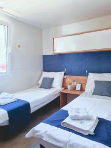 una habitación con 2 camas y una mesa con toallas en Bungalow Home Sweet Home - Logement complet, en Biograd na Moru