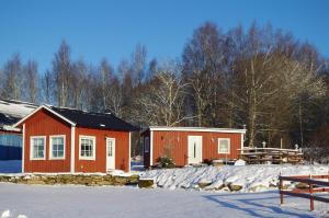 a couple of small buildings in the snow at Ekereds Gårdsstuga in Dalstorp
