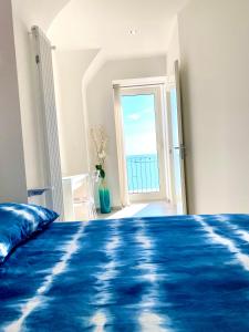 a bedroom with a blue bed and a large window at Bella Vista in Ortona
