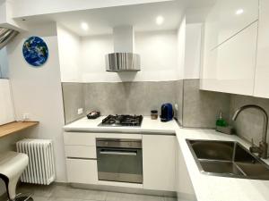a white kitchen with a sink and a stove at Bella Vista in Ortona