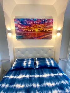 uma cama num quarto com uma pintura na parede em Bella Vista em Ortona
