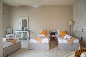Sala de estar con 2 camas y espejo en Golden Sun Boutique, en Malia