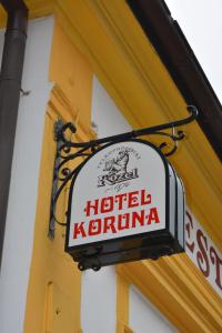 a sign for a hotel kronka on the side of a building at Hotel Koruna in Karlštejn