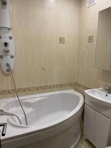 y baño con bañera blanca y lavamanos. en Кривой Рог, 95 квартал, Гагарина 3, Люкс апартаменты en Krivói Rog