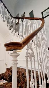 una escalera con barandillas blancas y una barandilla de madera en The Guards Hotel en Edimburgo