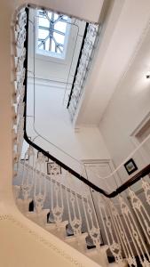 a staircase with a window and white rails at The Guards Hotel in Edinburgh