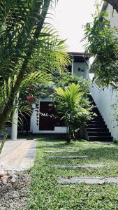 uma casa com um quintal com palmeiras e escadas em Kiara Sands em Mirissa