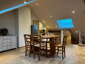 a kitchen with a table and chairs and a refrigerator at Gîte au pied du Mont in Saint-Maurice-sur-Moselle