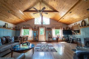 a living room with a wooden ceiling with a ceiling fan at Roscoe Cabin Pet friendly in Roscoe