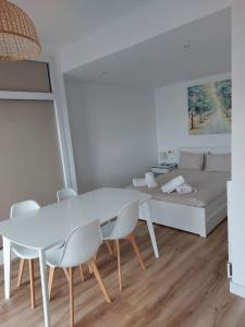 ein weißes Esszimmer mit einem weißen Tisch und Stühlen in der Unterkunft Apartamento en primera línea de playa A - Marbella Centro in Marbella