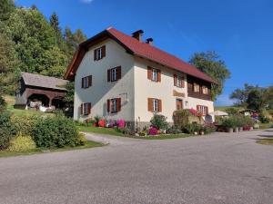a large white house with a red roof at Schlaferhof - Urlaub am Bauernhof in Fresach