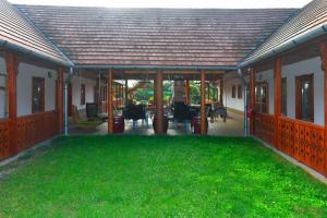 Szegi的住宿－Nyakigláb Villa，庭院中带绿草的开放式庭院