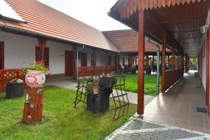 a building with a table and chairs in a yard at Nyakigl&aacute;b Villa in Szegi