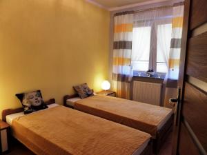 a room with two beds and a window at Apartamenty Silver Premium in Warsaw