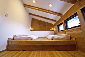 Tombi Lodge - Vacation STAY 14464v في Iiyama: سريرين في غرفة وأرضيات خشبية ونوافذ