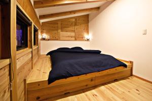 a bedroom with a bed in a room with wooden floors at Tombi Lodge - Vacation STAY 14464v in Iiyama