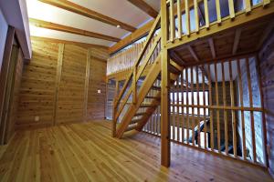 Tombi Lodge - Vacation STAY 14464v في Iiyama: درج خشبي في كابينة ذات أرضيات خشبية