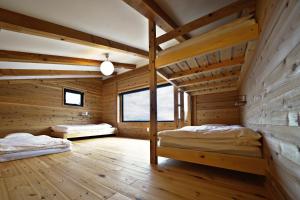 Tombi Lodge - Vacation STAY 14464v في Iiyama: سريرين في غرفة بجدران خشبية
