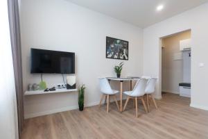 een eetkamer met een tafel en witte stoelen bij Cozy 2 bedroom apartment in the Gudauri centre - ski in/ ski out in Goedaoeri
