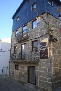 a stone building with a balcony on the side of it at Casa dos Conchos 2 in Sabugueiro