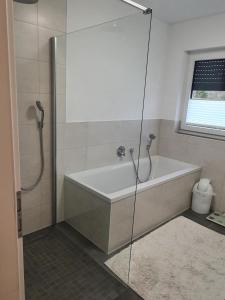 a bathroom with a bath tub and a shower at großzügige Unterkunft mit Terrasse in Oberbrechen