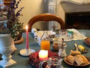 una mesa con una vela y una mesa con pan y zumo en La Maison Les Mimosas, en Le Minihic-sur-Rance