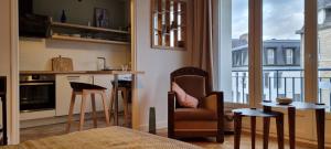 a living room with a chair and a kitchen with a balcony at Studio Roy Gradlon Quimper in Quimper