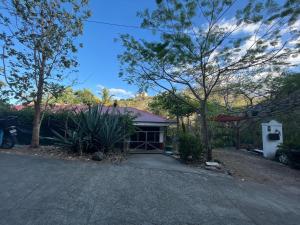 a house with a driveway in front of it at Casa Avi Fauna Nature Guesthouse Y Casa AlmaCalma in Ocotal