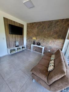 a living room with a couch and a tv at Altos del Potrero Apart in Potrero de los Funes