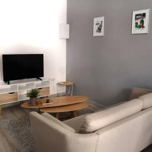 sala de estar con sofá y TV en TERRASSE du GET, en Revel