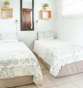 two beds in a room with a mirror at Klein Plekkie Self Catering Accommodation in Addo