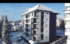 a large white building with snow on it at Apartman TIO Binis in Zlatibor
